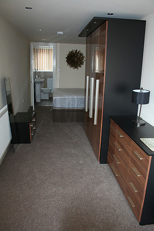Room 1  with en-suite. Walnut gloss wardrobes and furniture.